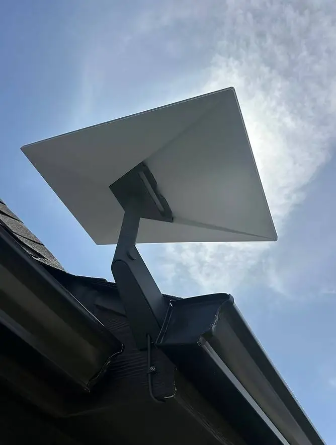 Starlink dish on a secure eave mount beside a roof gutter