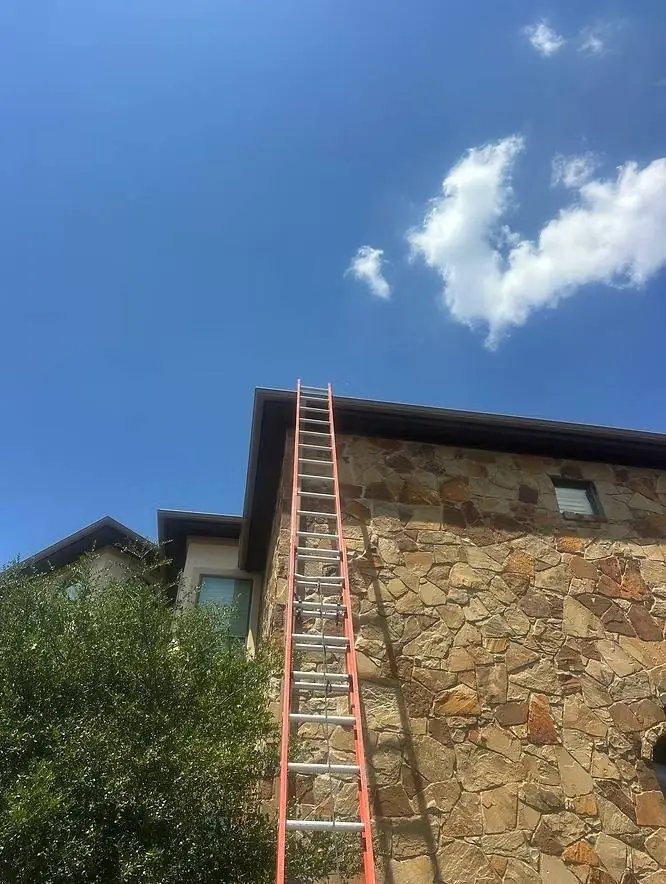 Starlink installer's ladder against a two-story stone home